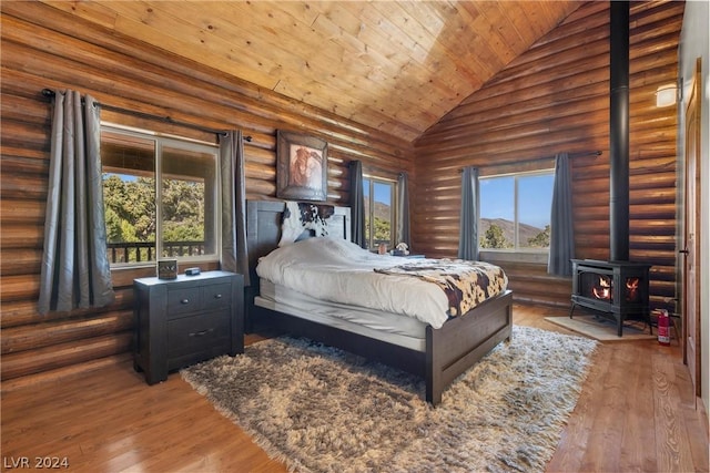 bedroom with wooden ceiling, a wood stove, rustic walls, and dark wood-type flooring