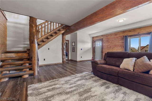 living room with dark wood-type flooring, beam ceiling, and wooden walls