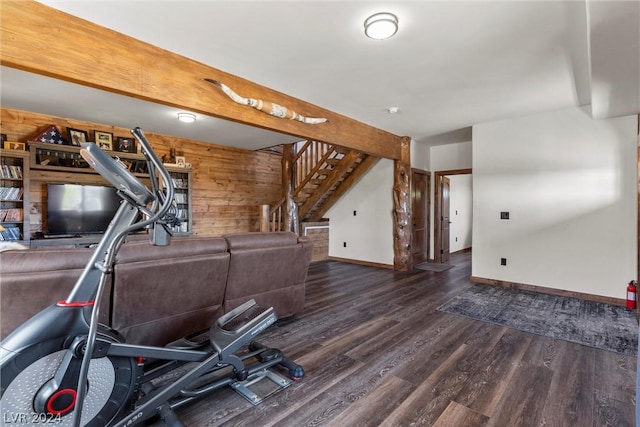 workout room with dark wood-type flooring and wooden walls