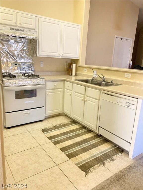 kitchen with white appliances, sink, premium range hood, light tile patterned floors, and white cabinetry