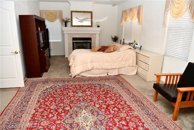 carpeted bedroom featuring a tiled fireplace