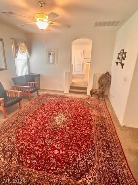 unfurnished living room featuring ceiling fan and carpet