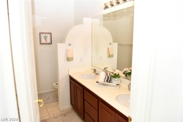 bathroom with vanity, toilet, and tile patterned flooring