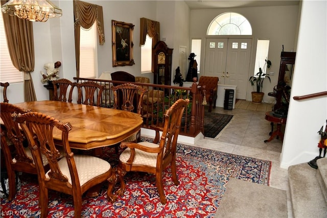 dining space with a healthy amount of sunlight, light tile patterned floors, and an inviting chandelier