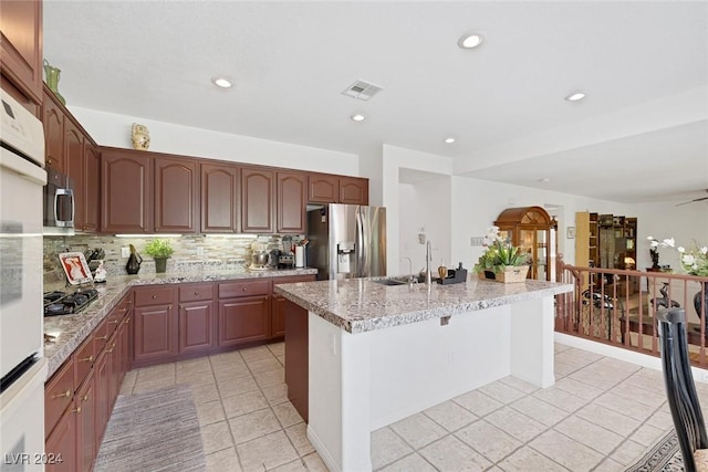3179 Surf Spray St, Las Vegas, NV 89117 - kitchen featuring stainless steel refrigerator with ice dispenser, light tile patterned floors, a center island with sink, decorative backsplash, and recessed lighting