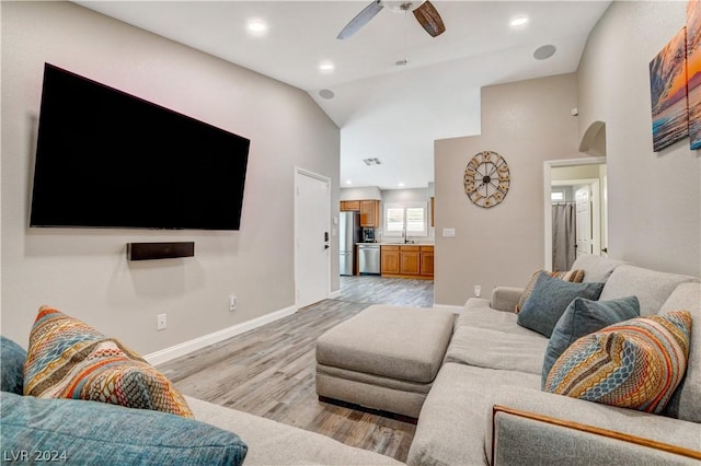 living room with ceiling fan, sink, high vaulted ceiling, and light wood-type flooring