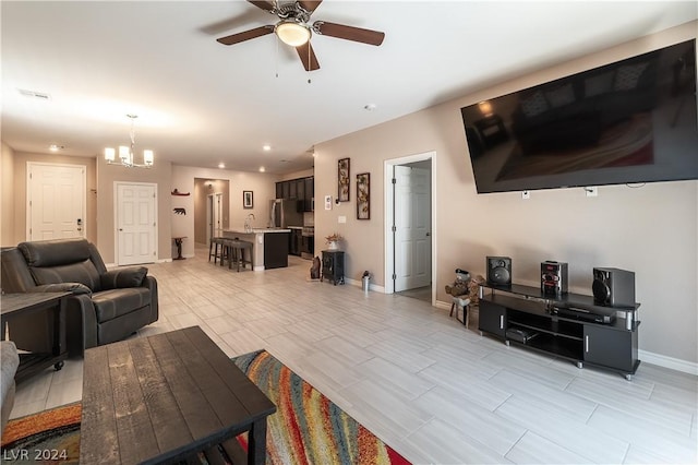 living room featuring ceiling fan with notable chandelier