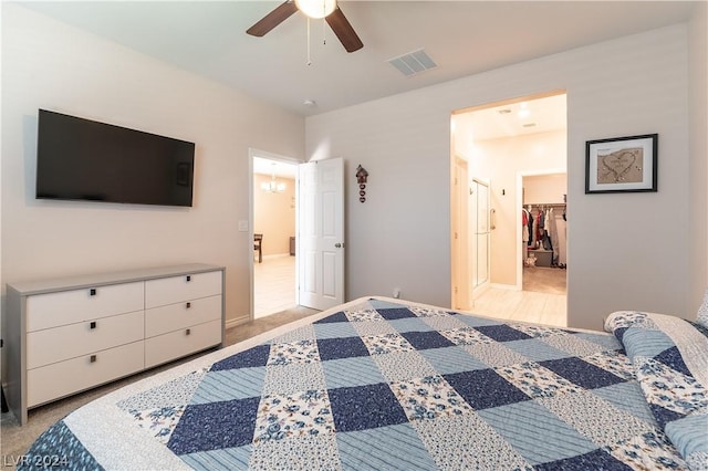 carpeted bedroom featuring a spacious closet, a closet, and ceiling fan