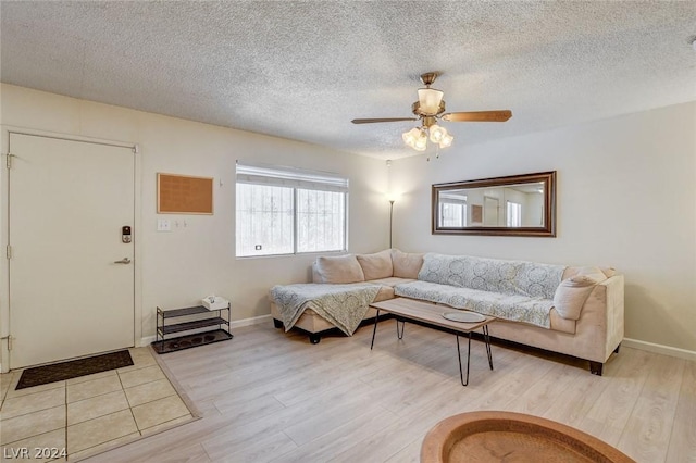 living room featuring a textured ceiling, ceiling fan, and light hardwood / wood-style floors