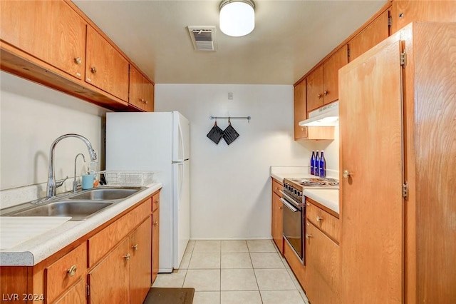 kitchen featuring sink, stainless steel electric range, light tile patterned floors, and white fridge