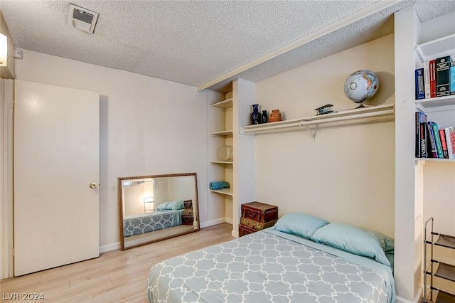 bedroom with wood-type flooring and a textured ceiling