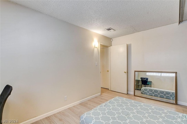 bedroom featuring hardwood / wood-style floors and a textured ceiling