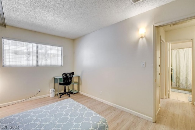 bedroom featuring hardwood / wood-style flooring and a textured ceiling