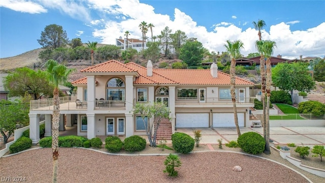 mediterranean / spanish home with a garage and a balcony