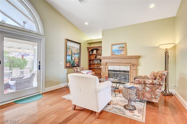 living room featuring high vaulted ceiling and light hardwood / wood-style flooring