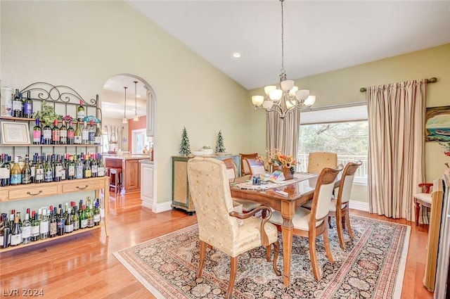 dining space with light wood-type flooring and a notable chandelier