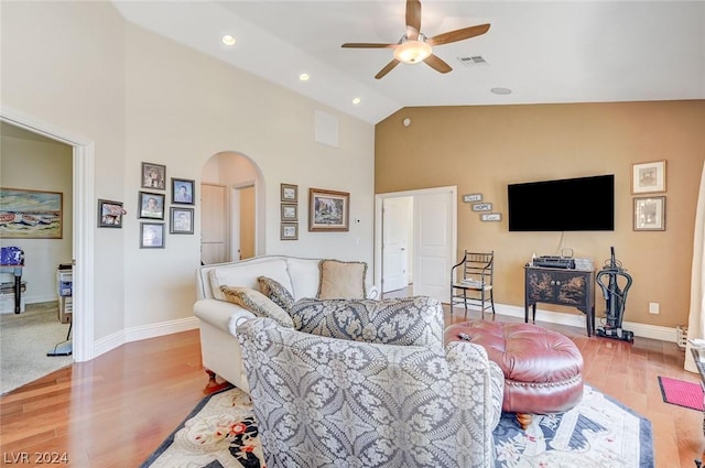 living room with ceiling fan, light hardwood / wood-style floors, and high vaulted ceiling