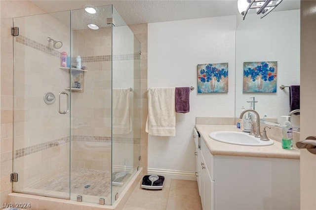 bathroom featuring tile patterned flooring, a textured ceiling, vanity, and walk in shower