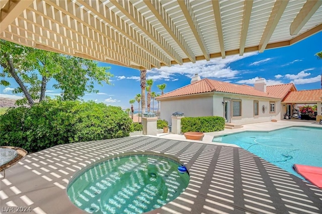 view of swimming pool featuring a jacuzzi, a pergola, and a patio area