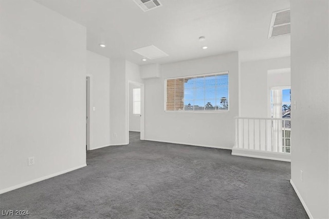 empty room with a healthy amount of sunlight and dark colored carpet