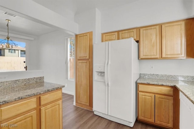 kitchen featuring decorative light fixtures, hardwood / wood-style floors, light brown cabinets, white fridge with ice dispenser, and light stone counters