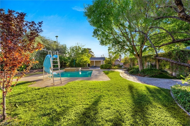 view of pool with a yard, a water slide, and a patio