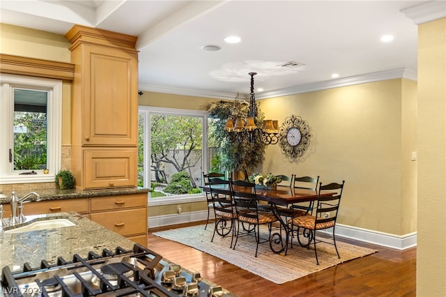 dining space featuring sink, dark hardwood / wood-style floors, a chandelier, and a healthy amount of sunlight