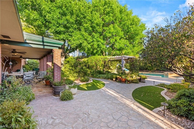 view of patio / terrace with ceiling fan and a pergola