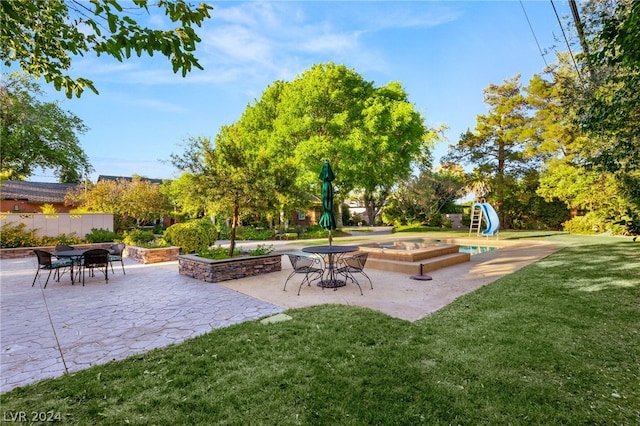 view of community featuring a pool with hot tub, a yard, and a patio