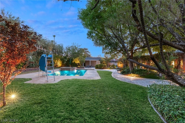 view of pool with a patio area, a yard, and a water slide