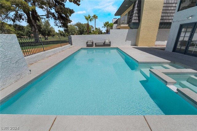 view of swimming pool with an in ground hot tub