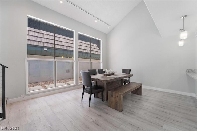 dining room featuring lofted ceiling and light hardwood / wood-style flooring