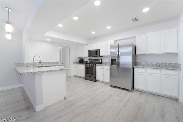 kitchen with hanging light fixtures, appliances with stainless steel finishes, sink, and white cabinets