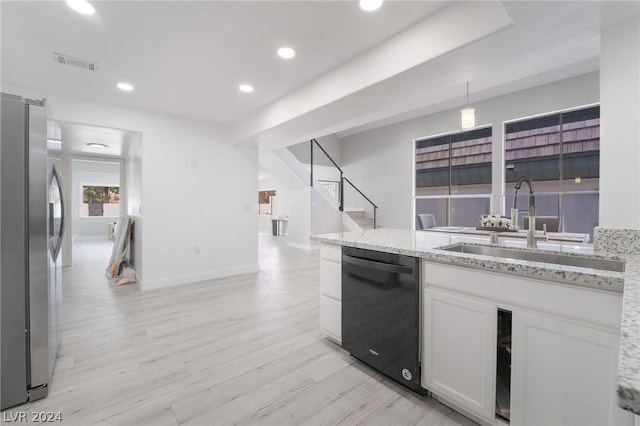 kitchen with sink, white cabinetry, stainless steel fridge, black dishwasher, and light hardwood / wood-style floors