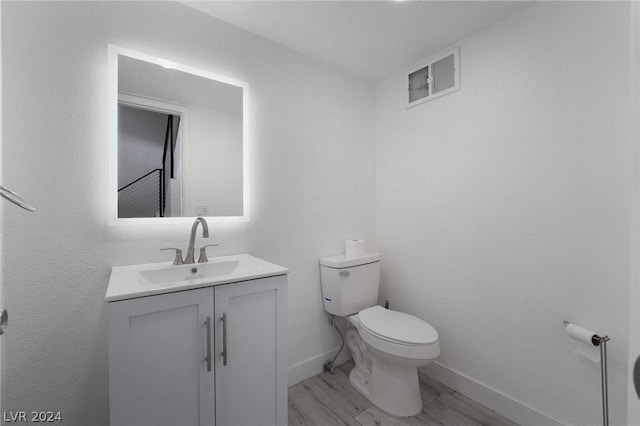 bathroom featuring vanity, hardwood / wood-style floors, and toilet