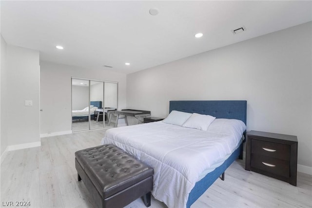 bedroom with light hardwood / wood-style floors and a closet