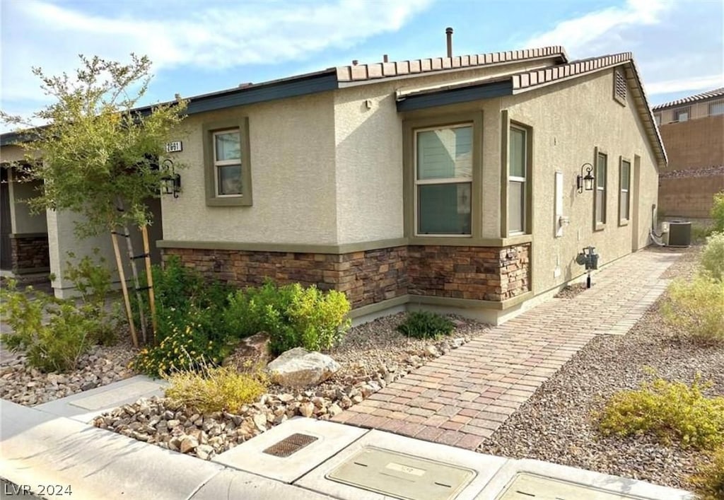 view of side of home with central AC unit