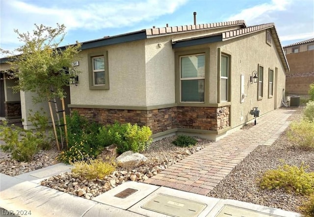 view of side of home with central AC unit