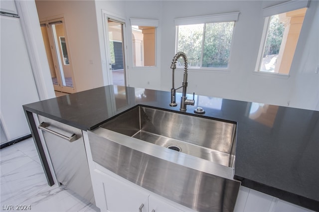 kitchen with sink, white cabinetry, and light tile patterned flooring