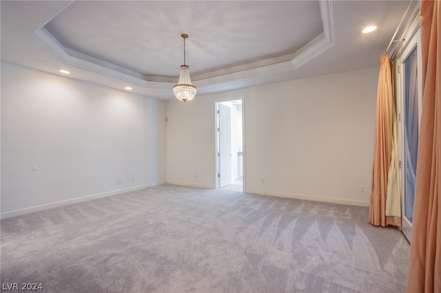 carpeted empty room featuring a raised ceiling