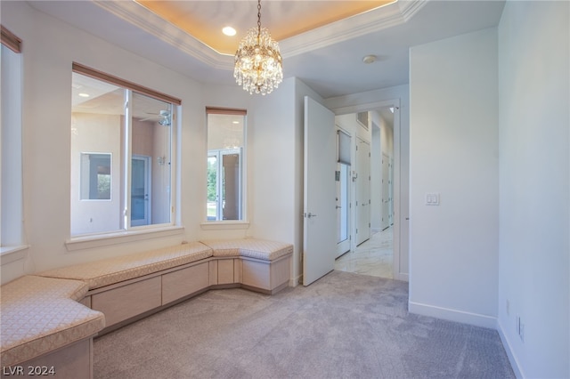 bathroom with tile patterned flooring, a notable chandelier, ornamental molding, and a tray ceiling