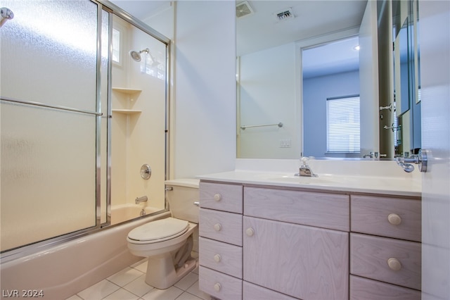 full bathroom with vanity, tile patterned floors, combined bath / shower with glass door, and toilet