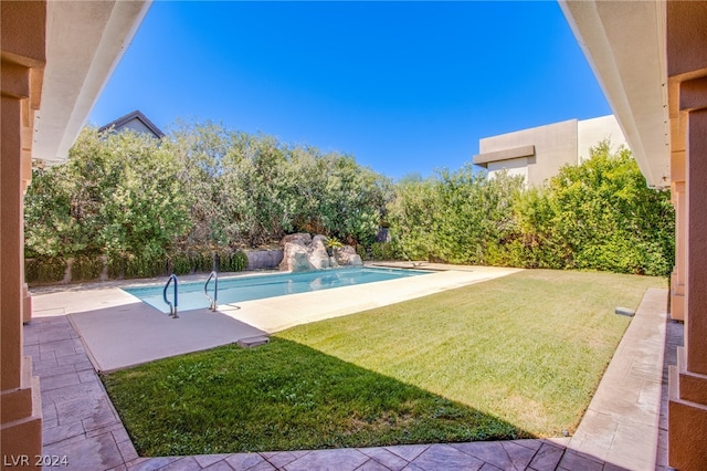 view of swimming pool featuring a patio and a lawn