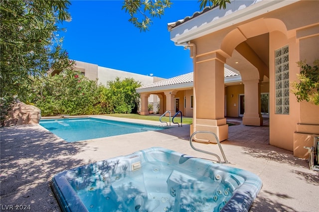 view of pool with a patio area and an outdoor hot tub