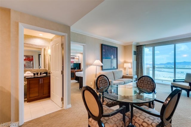 dining room with light tile patterned floors and crown molding