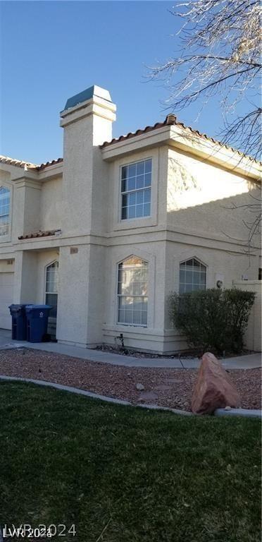 rear view of property with a lawn and a garage