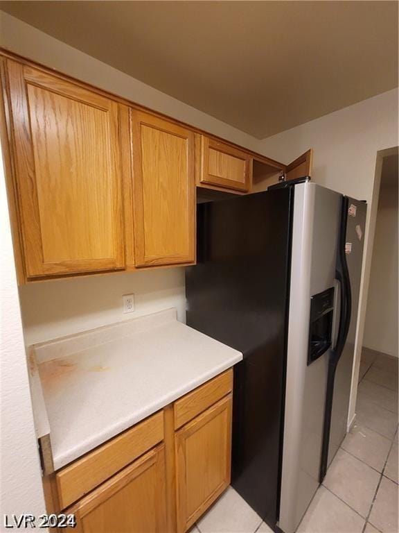 kitchen with stainless steel refrigerator with ice dispenser and light tile patterned floors