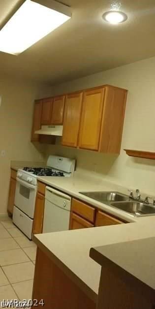 kitchen with light tile patterned flooring, sink, and white appliances