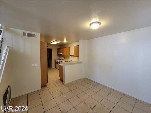 kitchen with light tile patterned flooring and white gas range