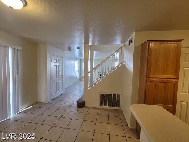 interior space featuring a wealth of natural light, tile patterned floors, and a textured ceiling